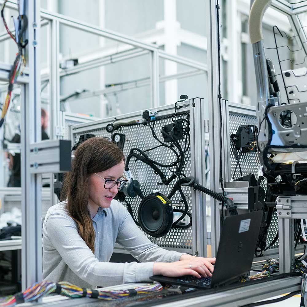 Young woman working on a laptop in a high tech lab.